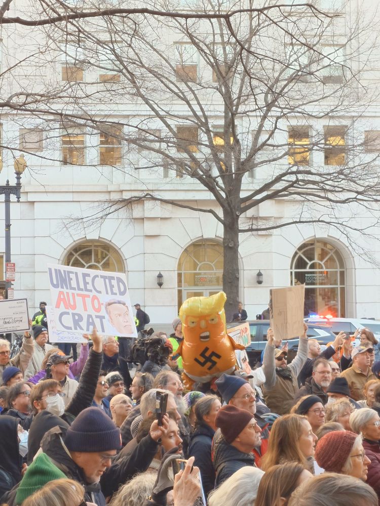 UNELECTED AUTO-CRAT (with picture of Elon Musk)
An inflated balloon of a diapered Donald Trump with a swastika on the front