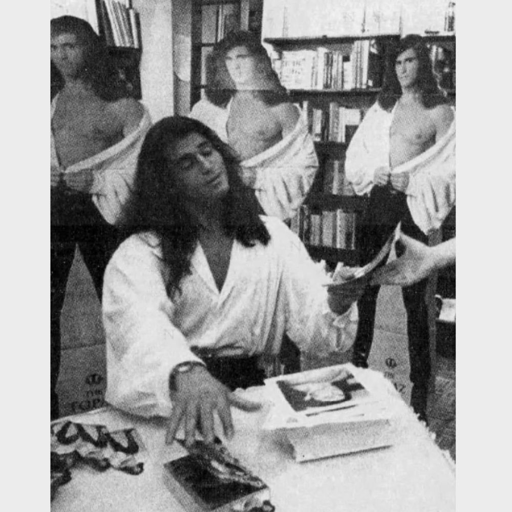 Topaz Man signing autographs in front of three cardboard cutouts of himself