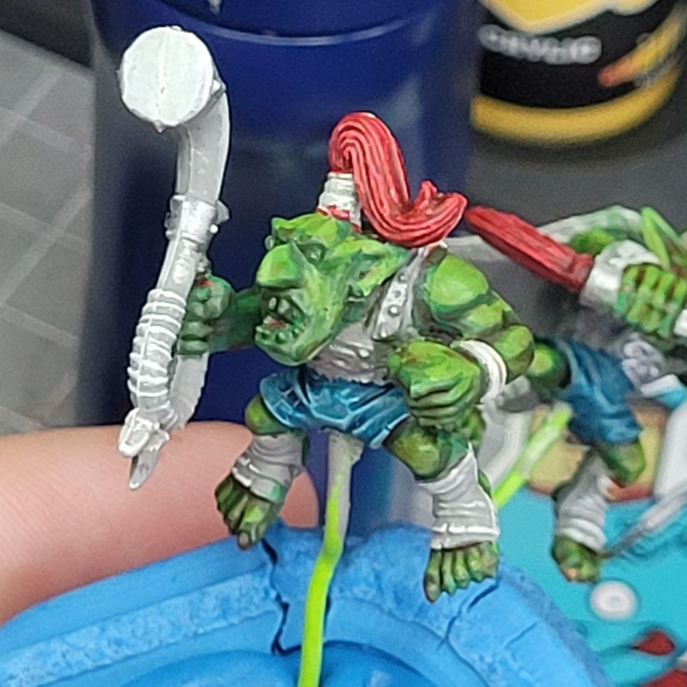 Close up of partially painted goblin from the Warhammer Old World Goblin Wolf Riders set. This one is holding a large horn and has red hair.