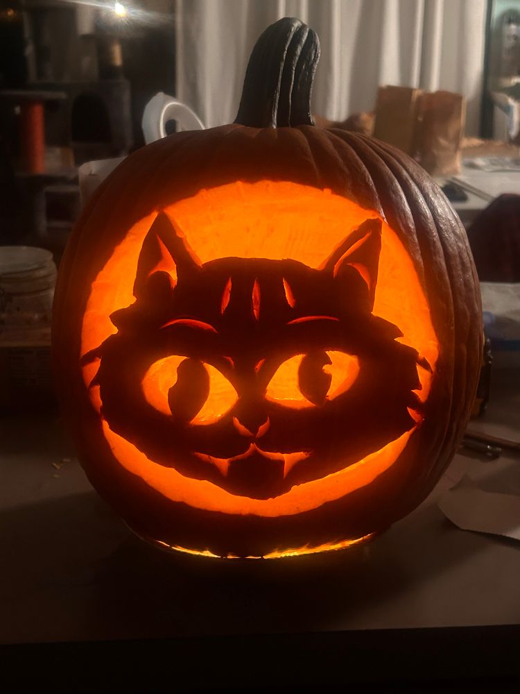 Jack o lantern with a carving of a cat face.