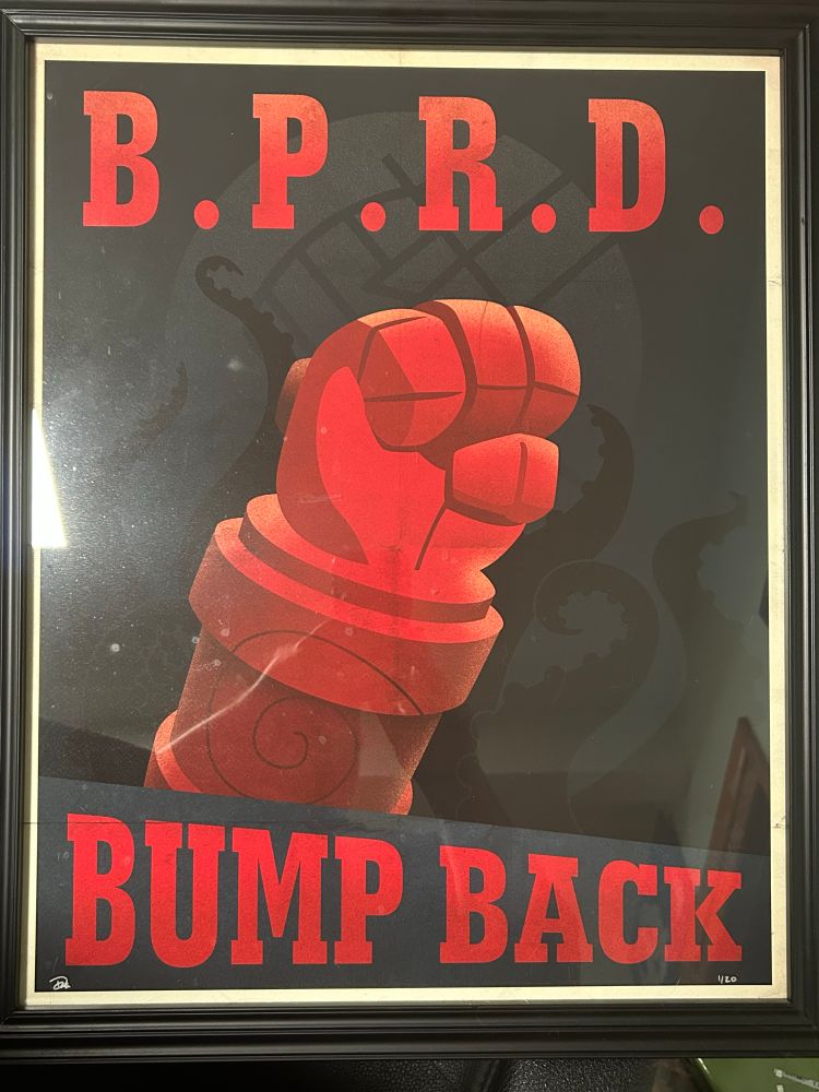 B.P.R.D. Propaganda style poster with a drawing of Hellboy’s giant red stone fist in the air and a stylized tentacle background in black and blue with text that reads, B.P.R.D. bump Back.