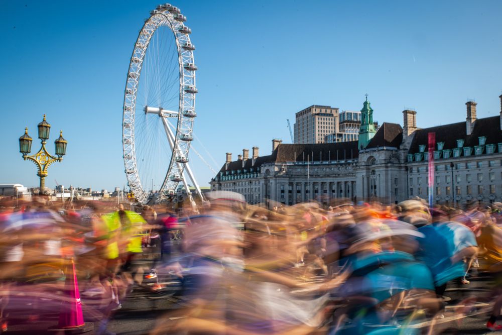 Runners pass in front of the London Eye on Westminster Bridge