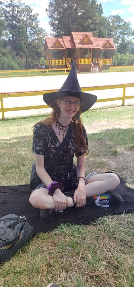 A cute witchy capybara sitting in front of the jousting arena.