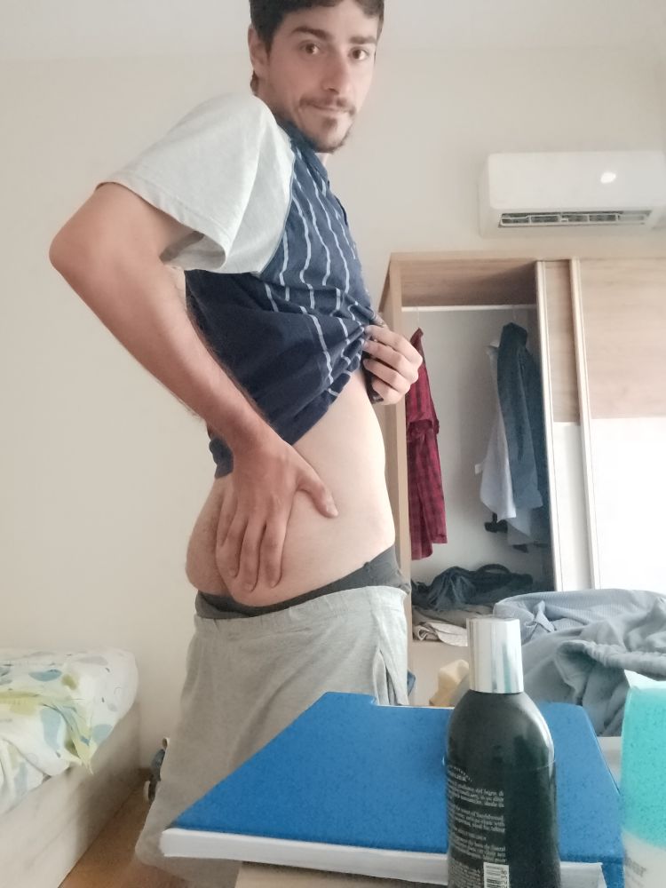 Me standing in front of my camera, facing it at 45°. I'm in my pyjamas and I'm slightly pulling my T-shirt while having my shorts and underwear pulled down to reveal my butt. I'm also holding my right butt cheek with my hand.