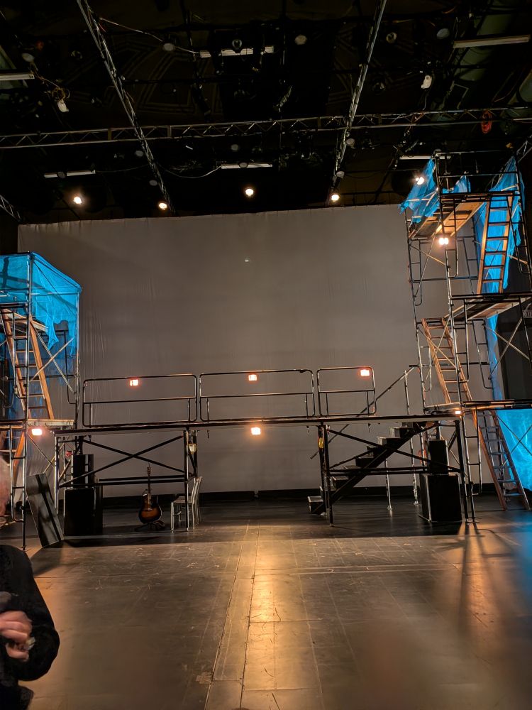 A stage set up with scaffolding and work lights. Two tall towers are on each end with stairs going to each level. 