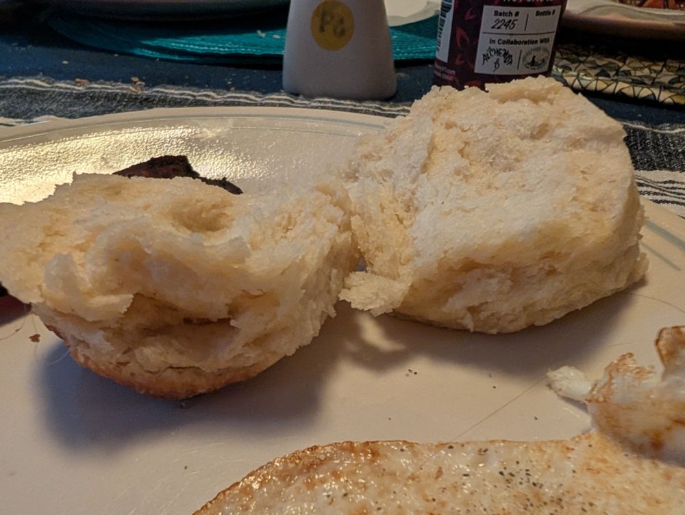 Flaky biscuit split in half showing some layers 