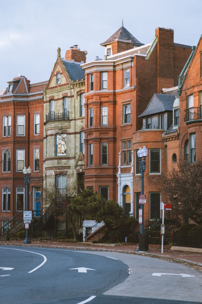 A series of row houses in Logan circle, DC. All red houses except for one green one 