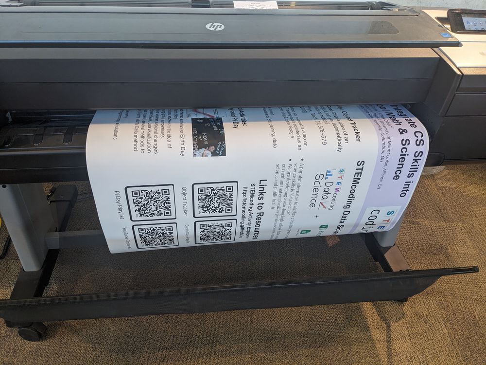 A photo of a poster being printed from a plotter