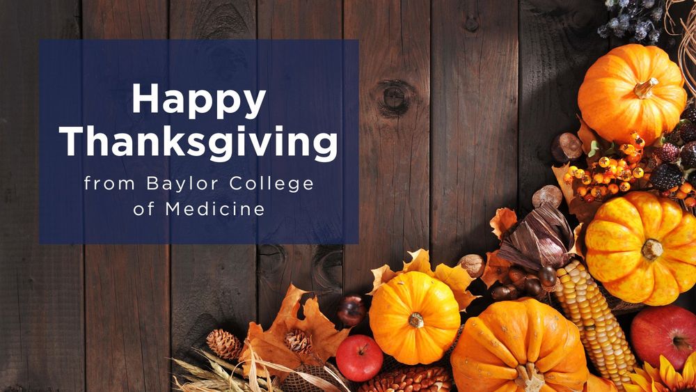 Happy Thanksgiving greeting with autumn pumpkins and decorations on a wooden background, from Baylor College of Medicine.