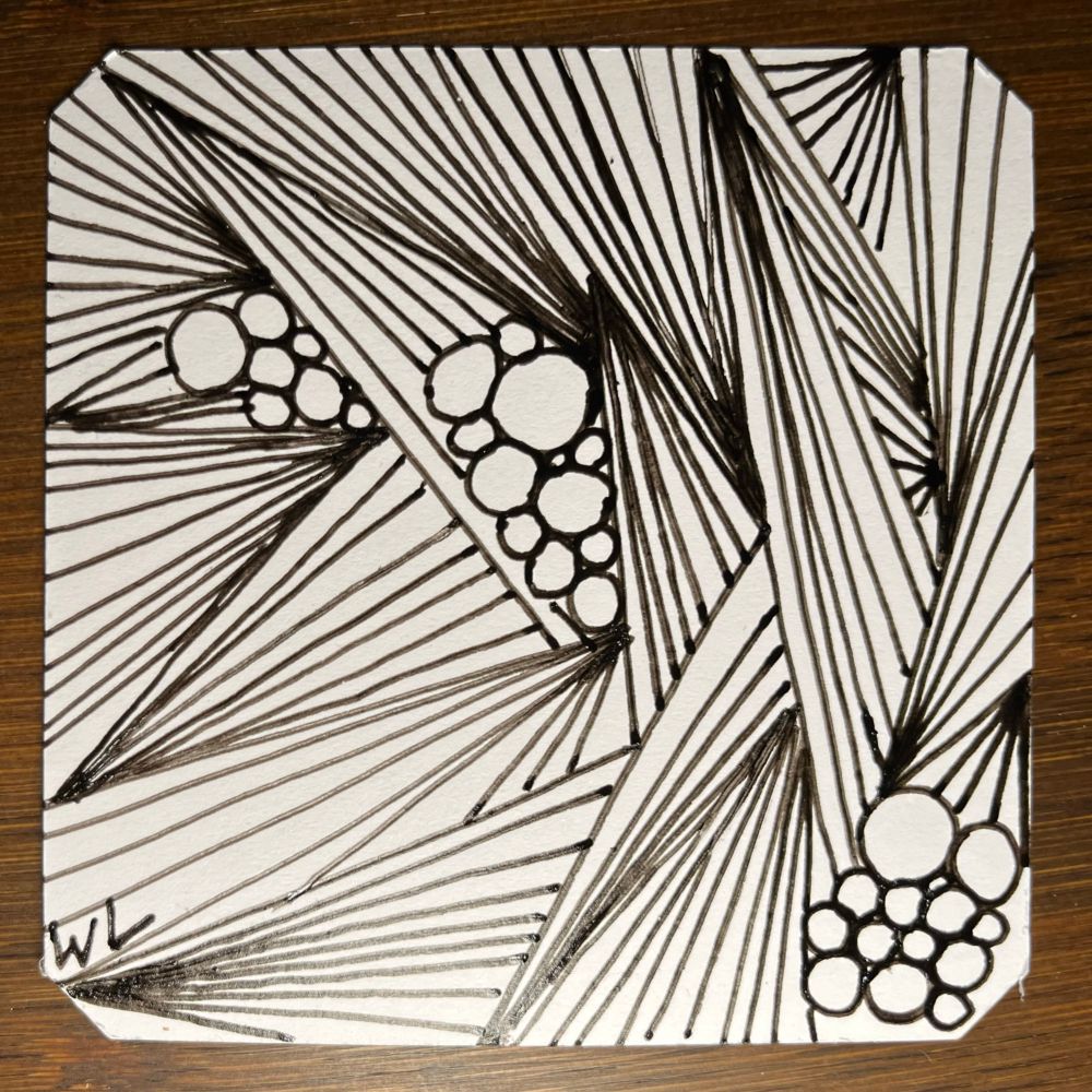 Abstract pen and ink drawing on a white square tile, resting on a dark wood surface. The drawing is composed of densely packed straight lines radiating outward from multiple points, forming large triangular or wedge shapes. Interspersed between these geometric line patterns are clusters of small and medium-sized circles, which appear to be grouped like grapes or bubbles, creating a contrast of curved and straight lines. The overall design is high contrast black and white, dynamic, and  signed "WL" in the lower left corner.