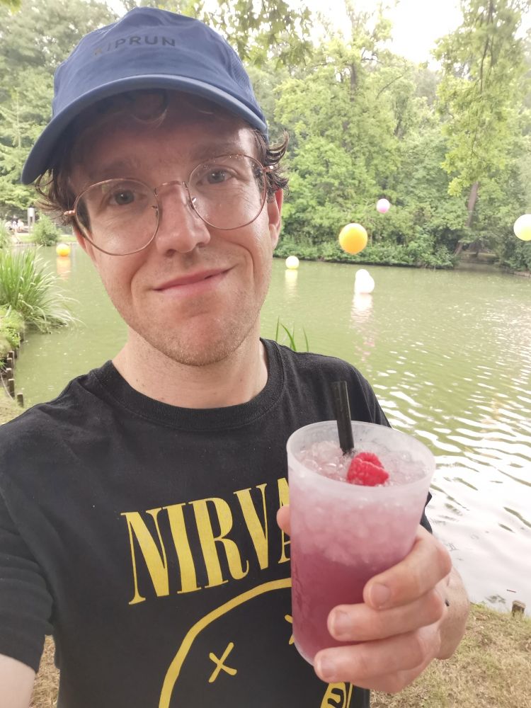 Pieter Van der Schoot met blauwe pet, Nirvana-T-shirt en cocktail op Rock Herk 2025