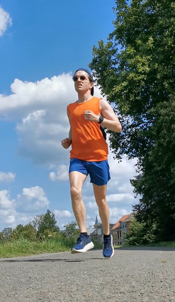 Pieter Van der Schoot loopt in short en mouwloos shirt onder de zomerzon. 