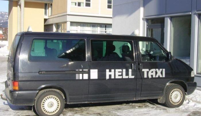 A black VW minibus parked outside a building. It has 