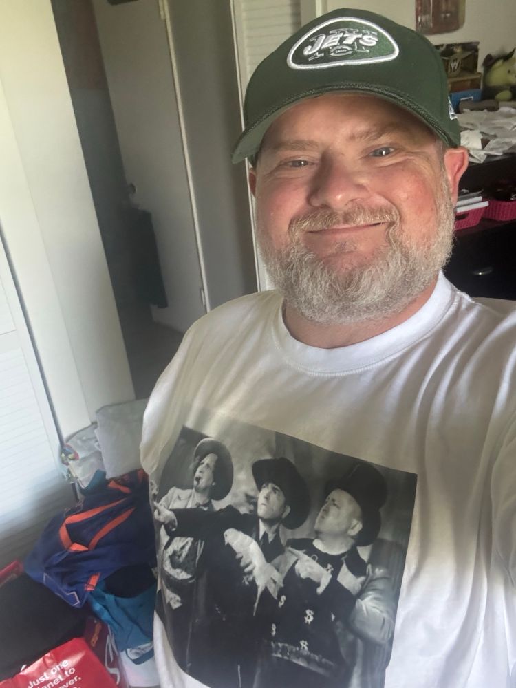 Selfie wearing a Jets cap and a Three Stooges t-shirt, linking the two squads in their ridiculousness.