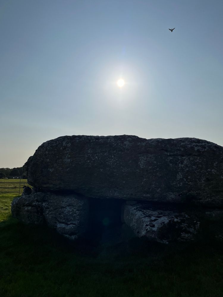 Lligwy Burial Chamber with the sun just behind it