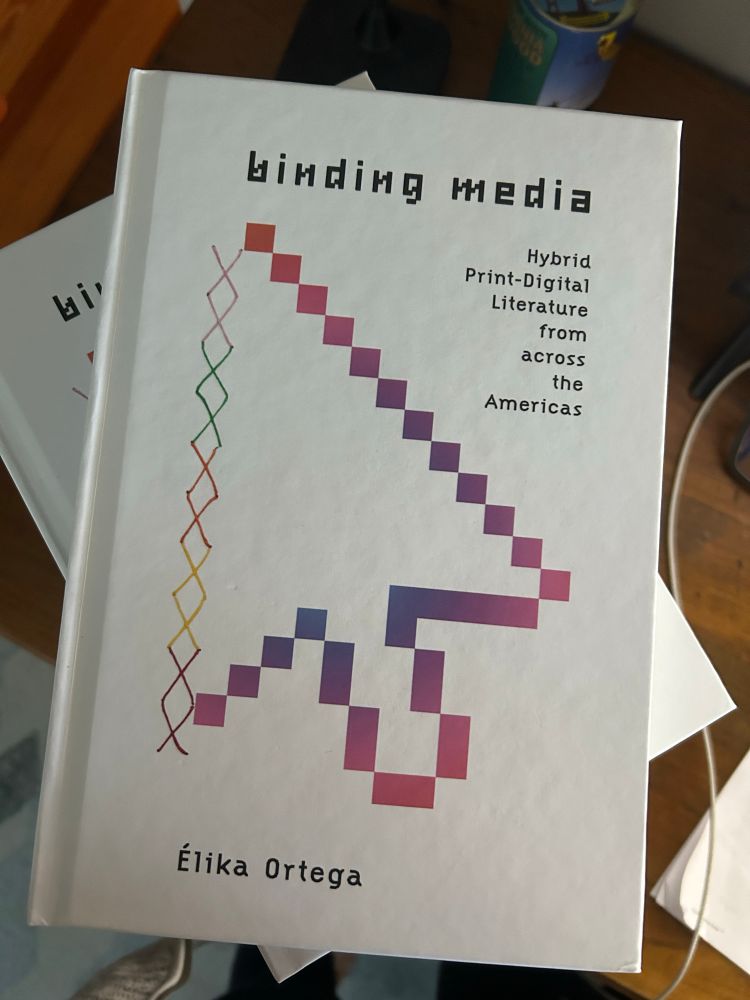 The gorgeous front cover of Binding Media. Hybrid Print-Digital Literature from across the Americas. It shows a pixelated cursor half of it is made of binding stitches. 