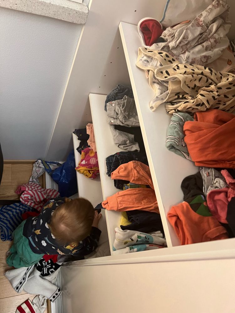 Vauva tyhjentää vaatekaapin alinta hyllyä.