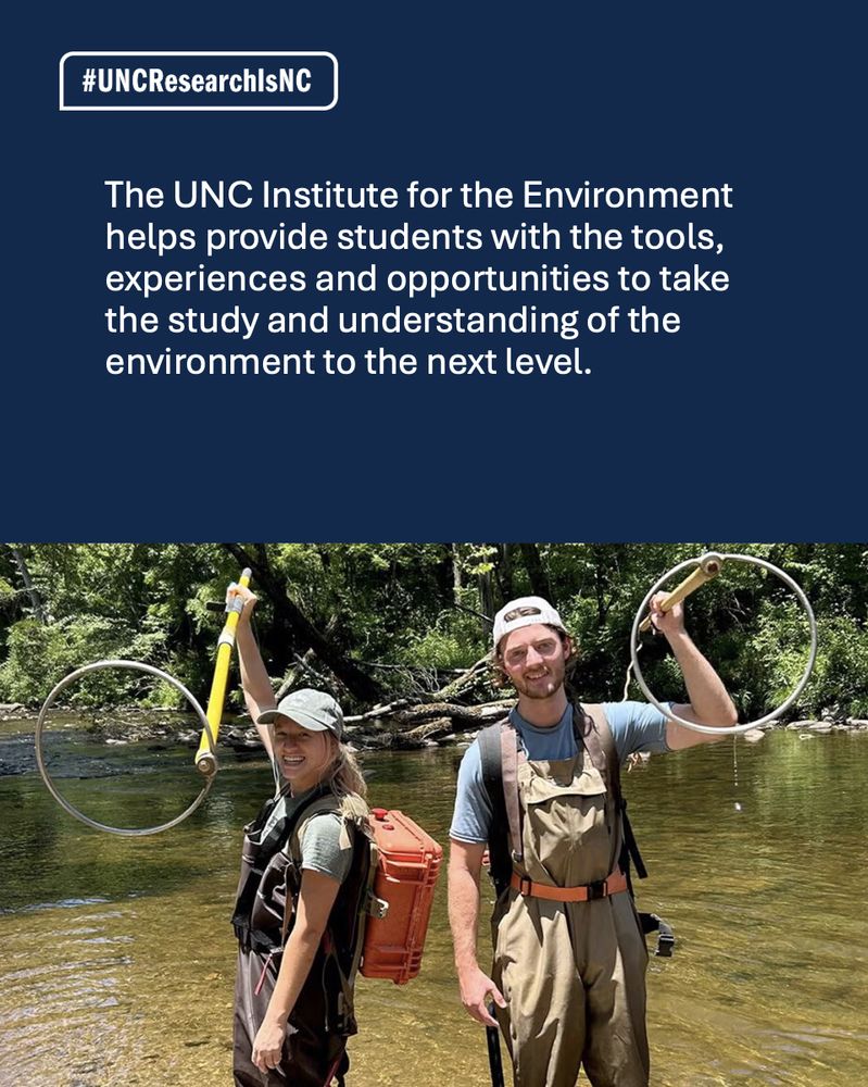 Two students hold research tools in a river.