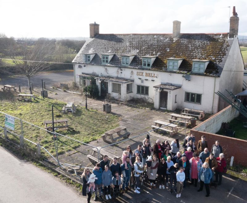 Group of volunteers outside a closed pub. 