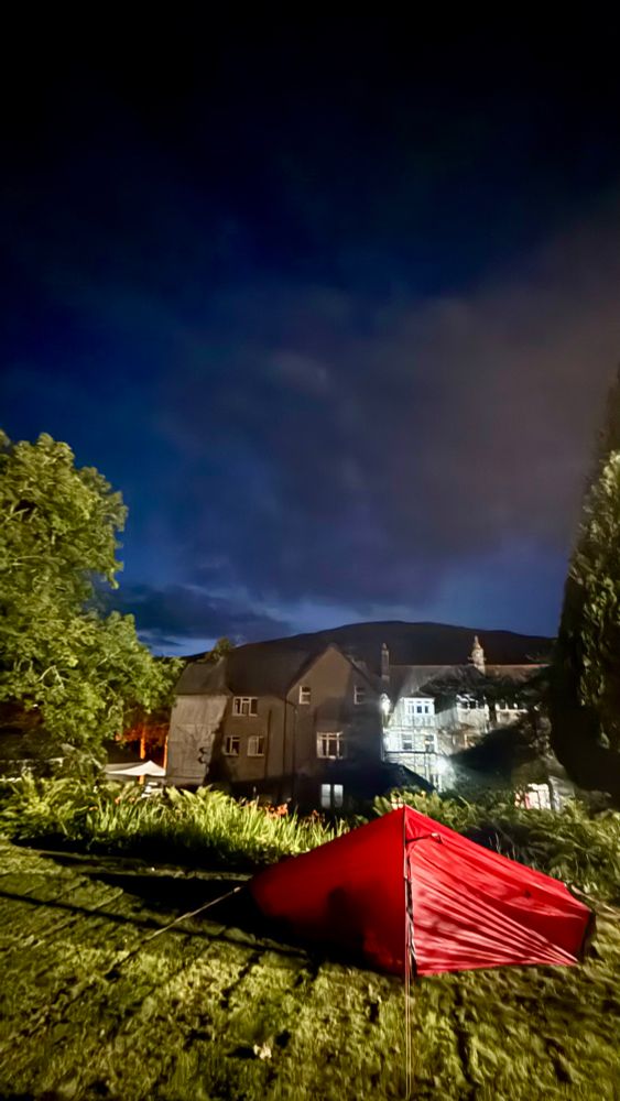 Red Hilleberg Akto tent pitched in front of an old school in the English Lake District
