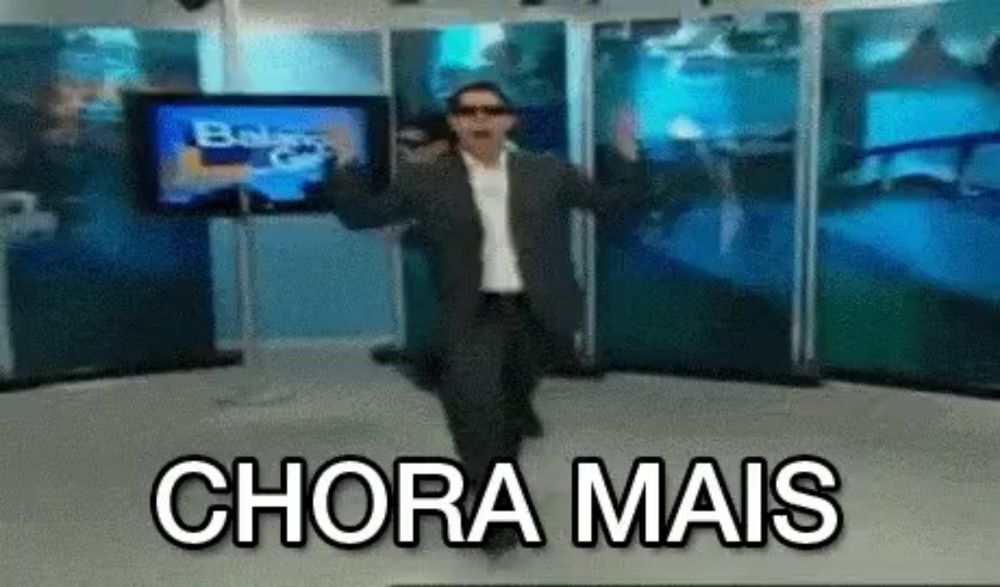 a man in a suit and sunglasses is dancing in front of a screen that says chora mais .