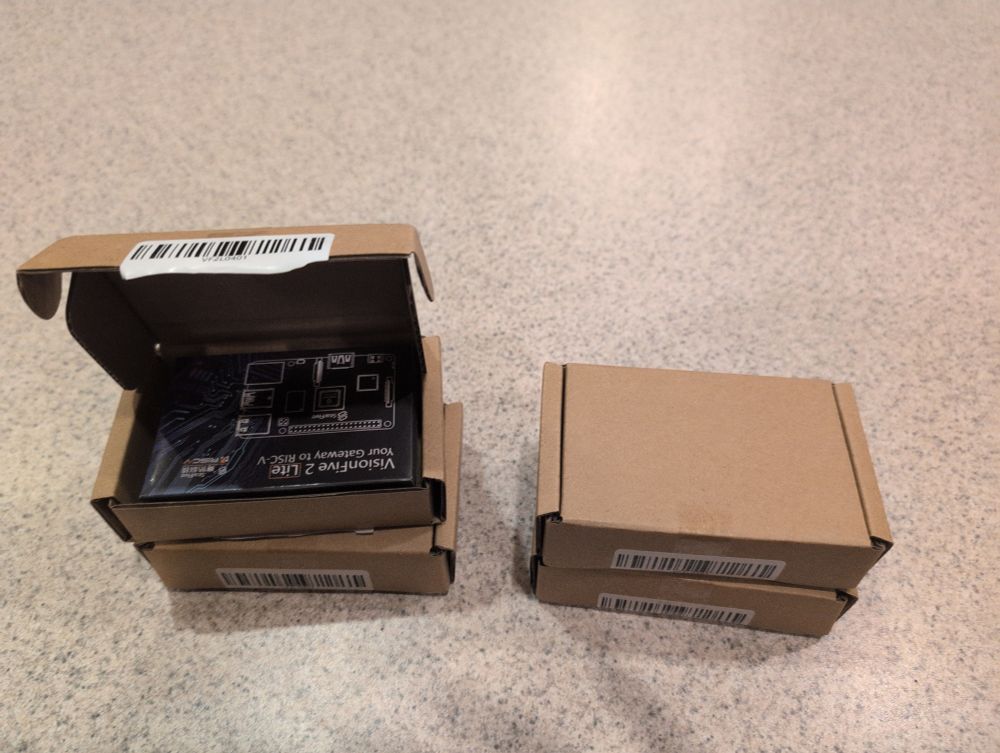 A picture of 4 boxes each containing a VisionFive 2 Lite. One of them is open, showing the VisionFive 2 Lite box inside.