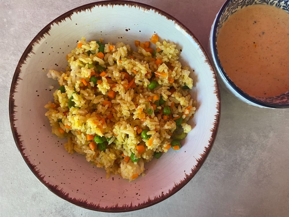 Bratreis alá Asia-Imbiss mit einem Schälchen rotemr Thaicurry-Soße