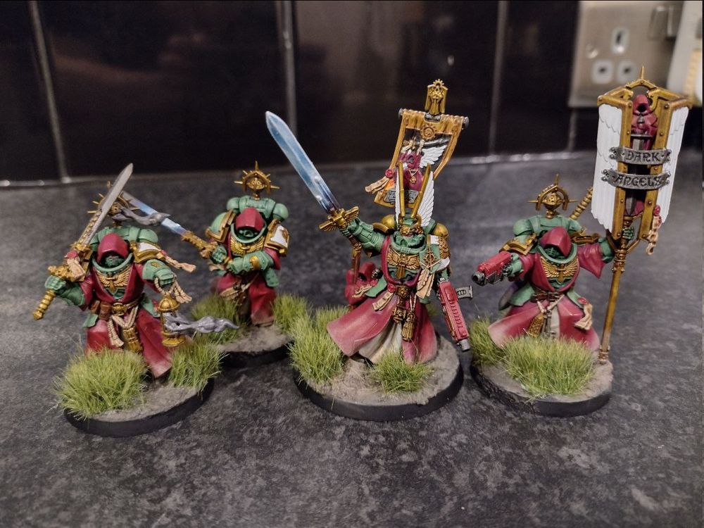 Picture of robed space marine models from Warhammer 40k known as "Inner Circle Companions" alone with a larger character known as Azrael.