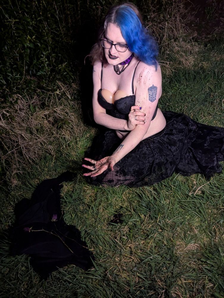 Me outside in the distorted, overgrown grass, starting to get dirt on myself down my arm as I look at the dead roses from last month 