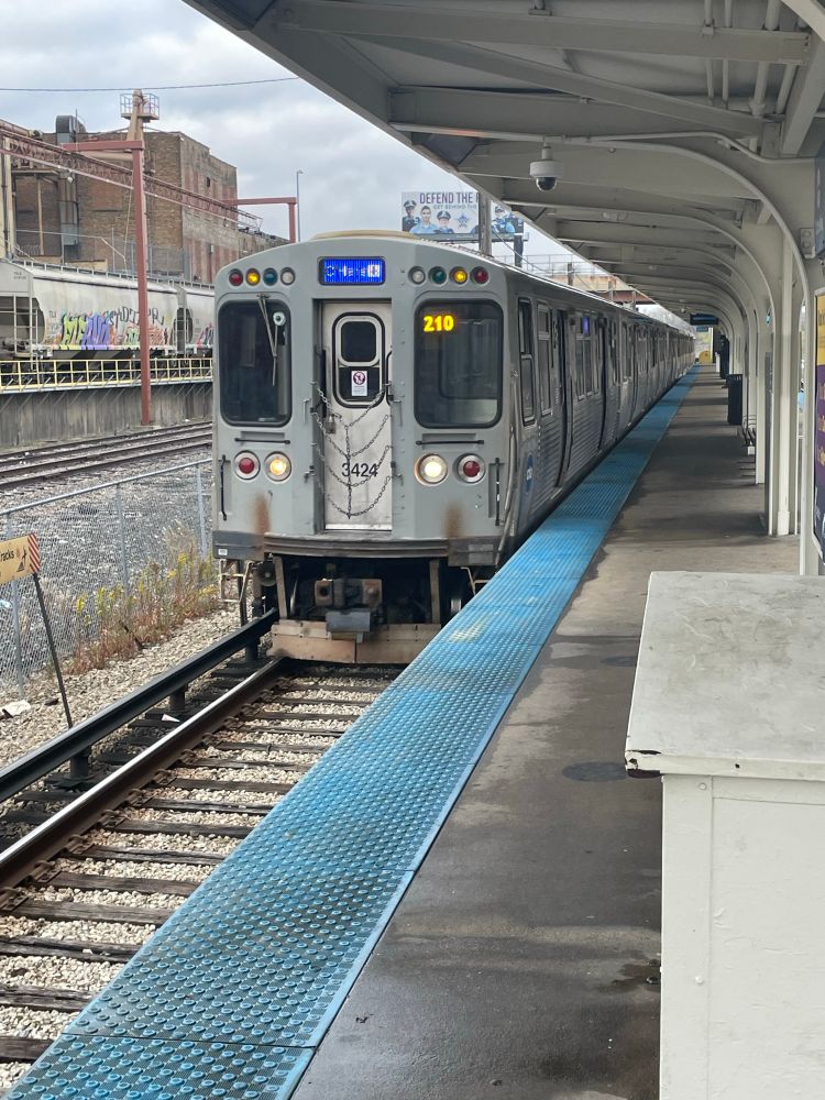 A CTA Blue Line train arrives at Harlem-Forest Park.