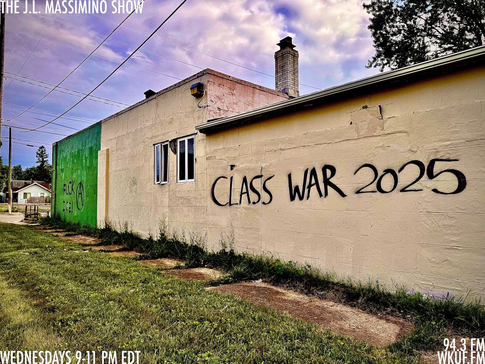 FUCK I.C.E., an awkward attempt at an anarchy symbol, and CLASS WAR 2025 graffitied on the side of an abandoned building on the west side of Flint, Michigan. THE J.L. MASSIMINO SHOW WEDNESDAYS 9-11 PM EDT 94.3 FM WKUF.FM has been added to the image.