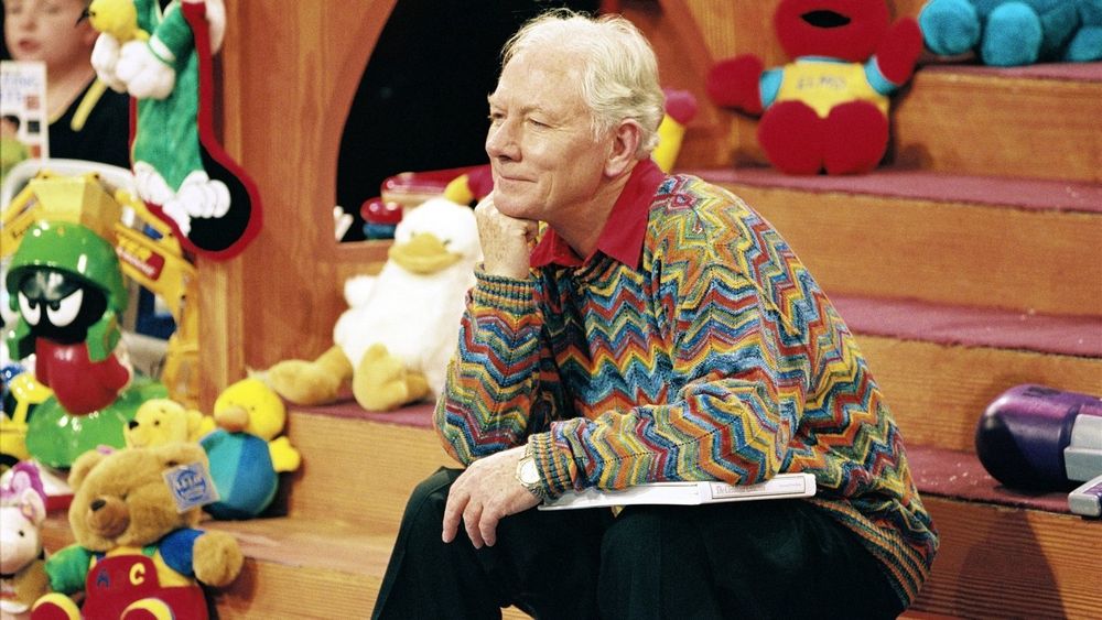Gay byrne dressed in Christmas jumper surrounded by toys on ‘the late late toy show’.  