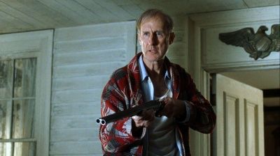 James Cromwell (farmer in babe)  in the film the green mile standing on a porch of a wooden house in his robe holding a rifle. 