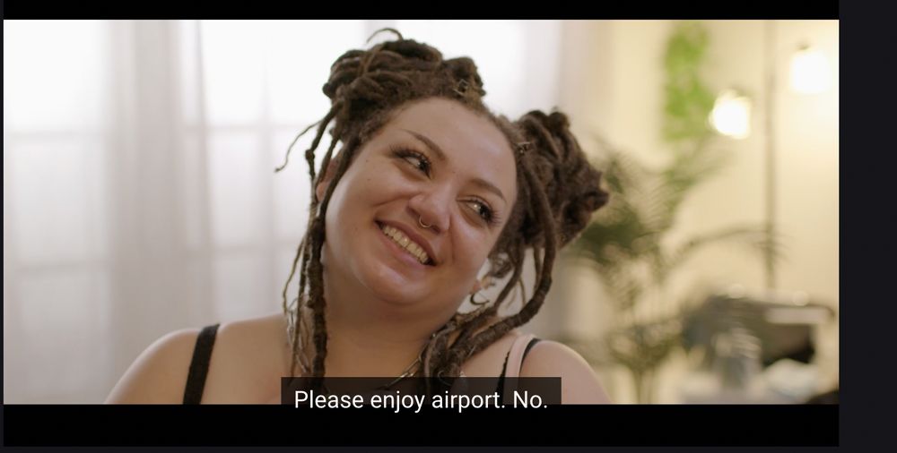 Figs Fantasy looks off camera with a smile. The caption text incorrectly reads "Please enjoy airport. No." 