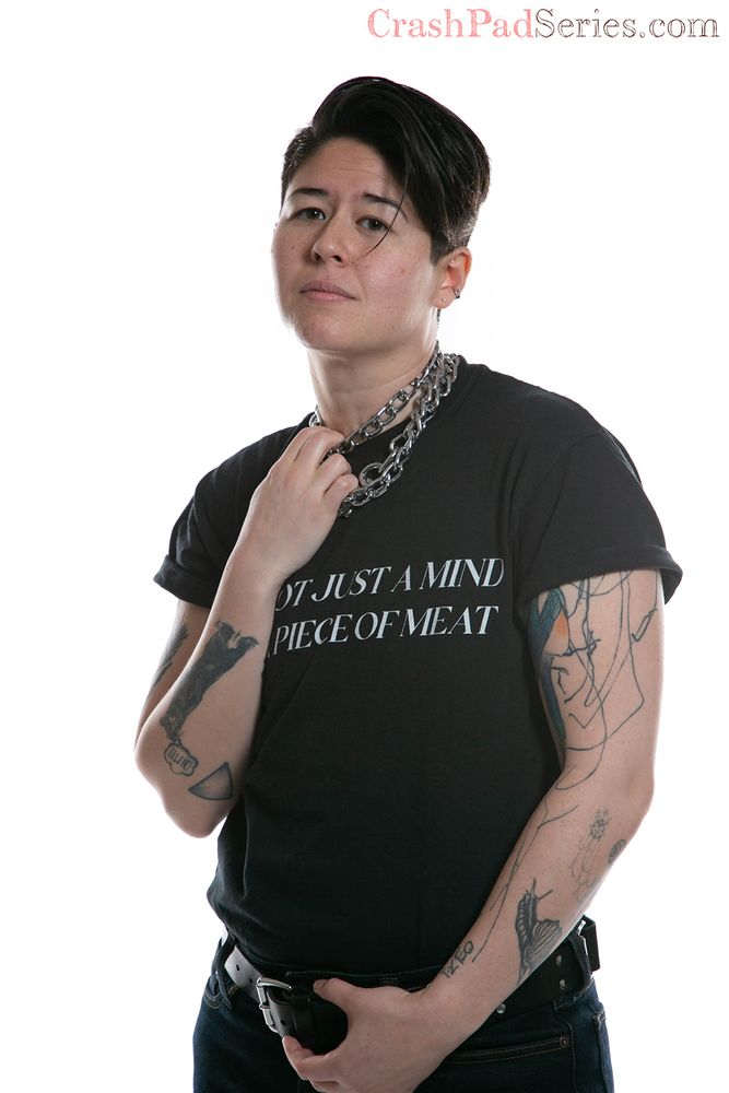 Beau Flex poses wearing a shirt that reads "I am not just a mind, I am a piece of meat."