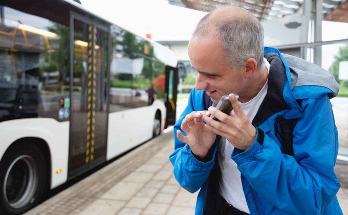 Illustrative image of a blind person checking information on his phone at a bus stop. Photo: Getty Images / istockphoto.com / SilviaJansen
