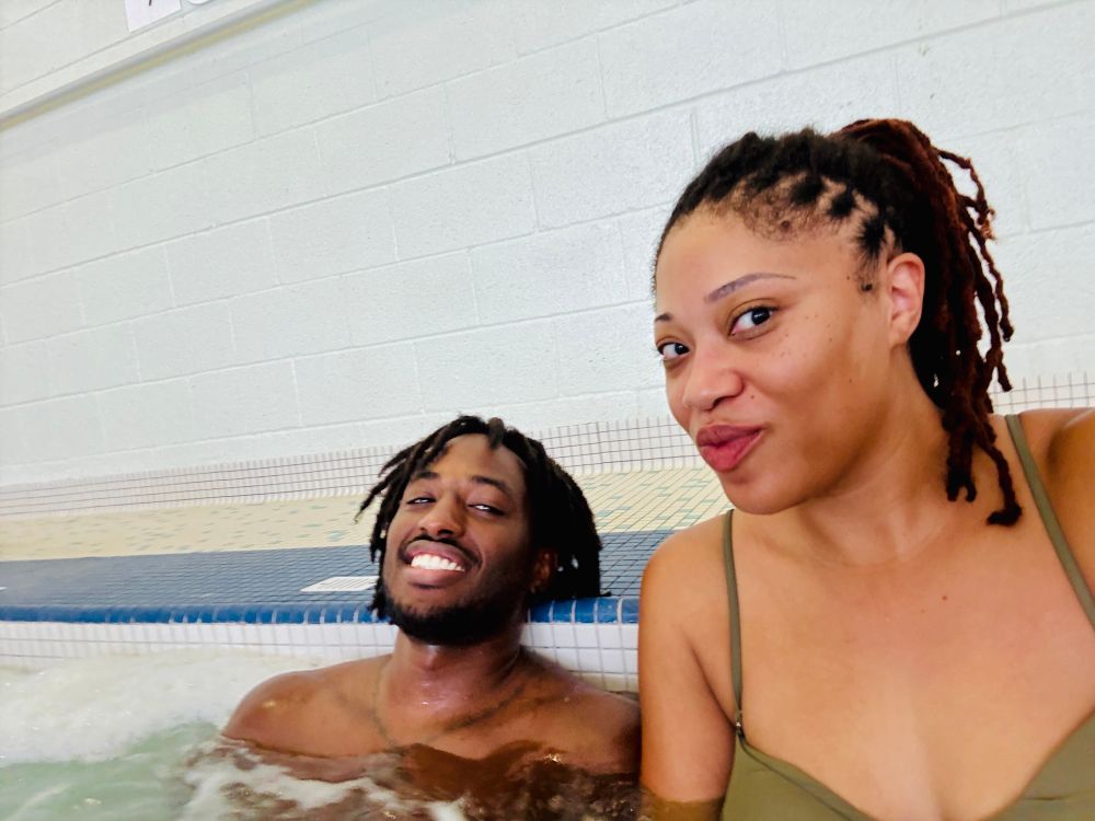 A Black woman and man with locs taking a  selfie in the gym hot whirlpool 