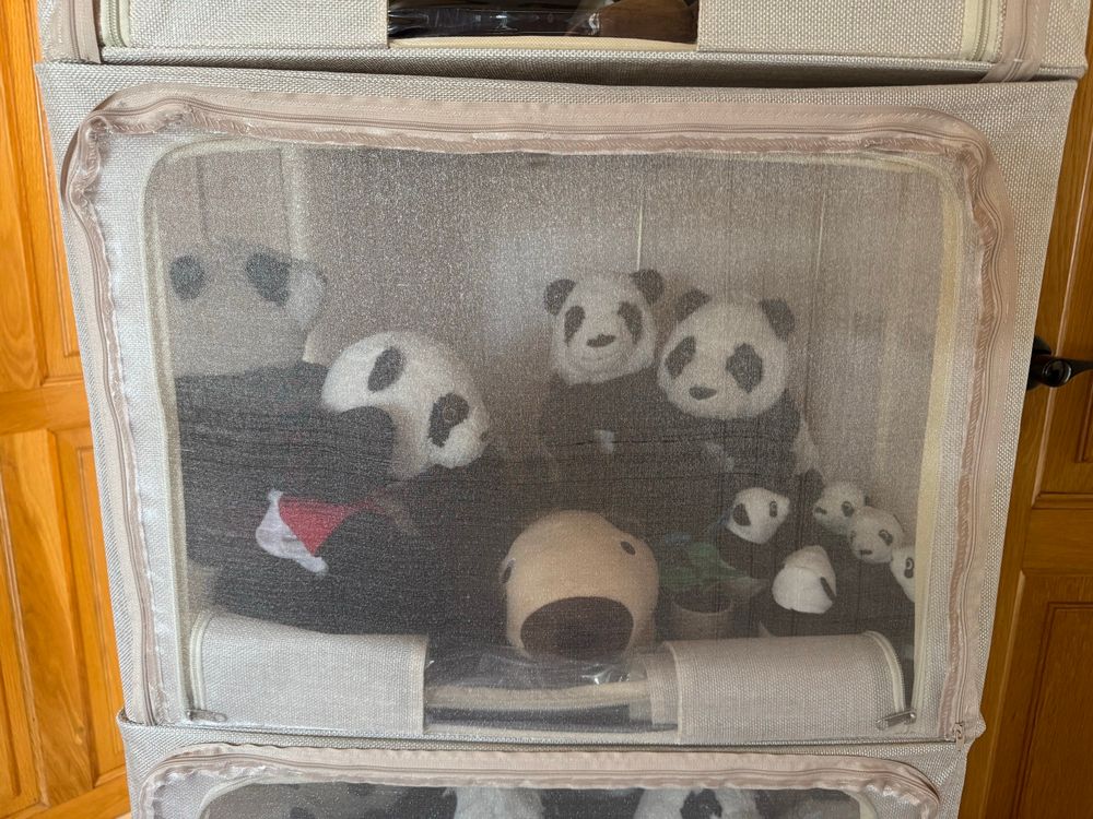 a clothes storage container with a hand-sewn organza window, attached with a zipper, with stuffies inside
