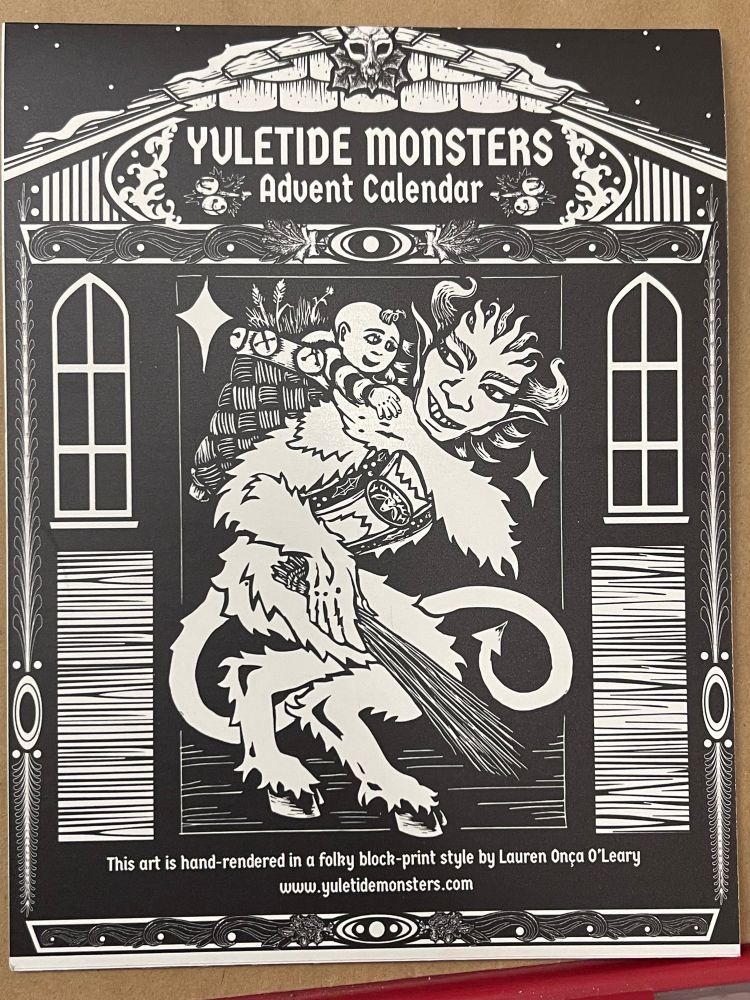 A black and white block-print advent cover. It has a friendly looking Krampus, a creature with hooves and horns, carrying a sack that has a baby in it. They appear in a doorway of a home. The title reads “yuletide monsters advent calendar” and below the art it reads, “This art is hand-rendered in a folky block-print style by Lauren Onca O’Leary. 
