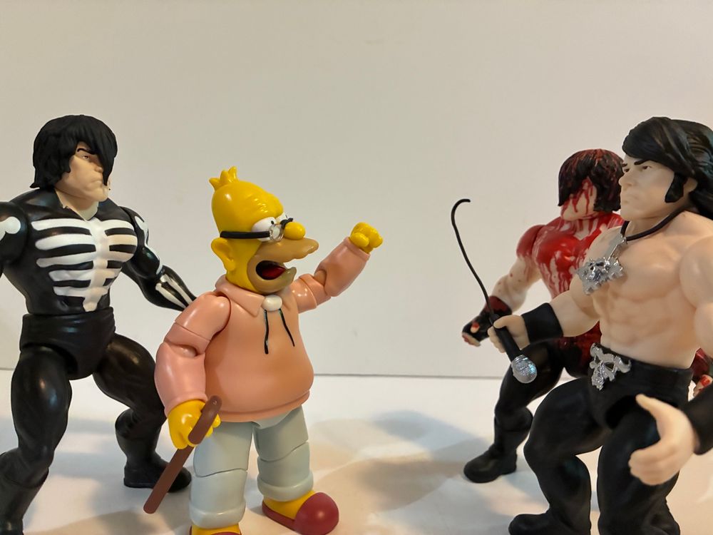 Jakks Pacific Grandpa Simpson action figure with a Super7 Misfits Glenn Danzig standing behind him. He’s yelling at the Super7 Samhain and Danzig era Glenn Danzig figures who don’t wear shirts.