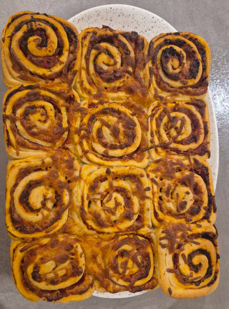 12 pizza whirls stuck together in four rows of three. They are made with pizza dough spread with tomato puree, a selection of cured meats (prosciutto, salami, pepperoni, and ham), and mozzarella and cheddar cheeses. Oh, and a sprinkling of basil cause I'm fancy.