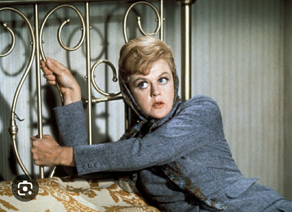 Angela Landsbury hanging on to a brass headboard in Bedknobs and Broomsticks