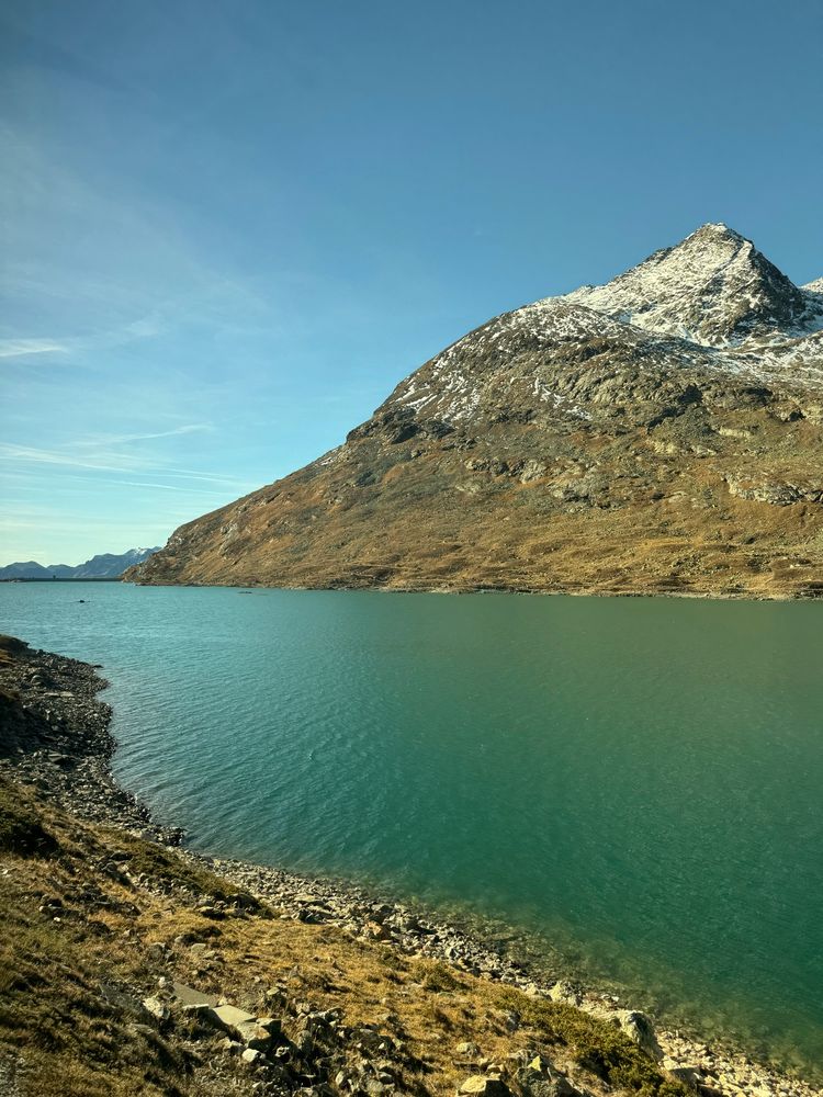 A blue lake with mountains sloping down to it. 