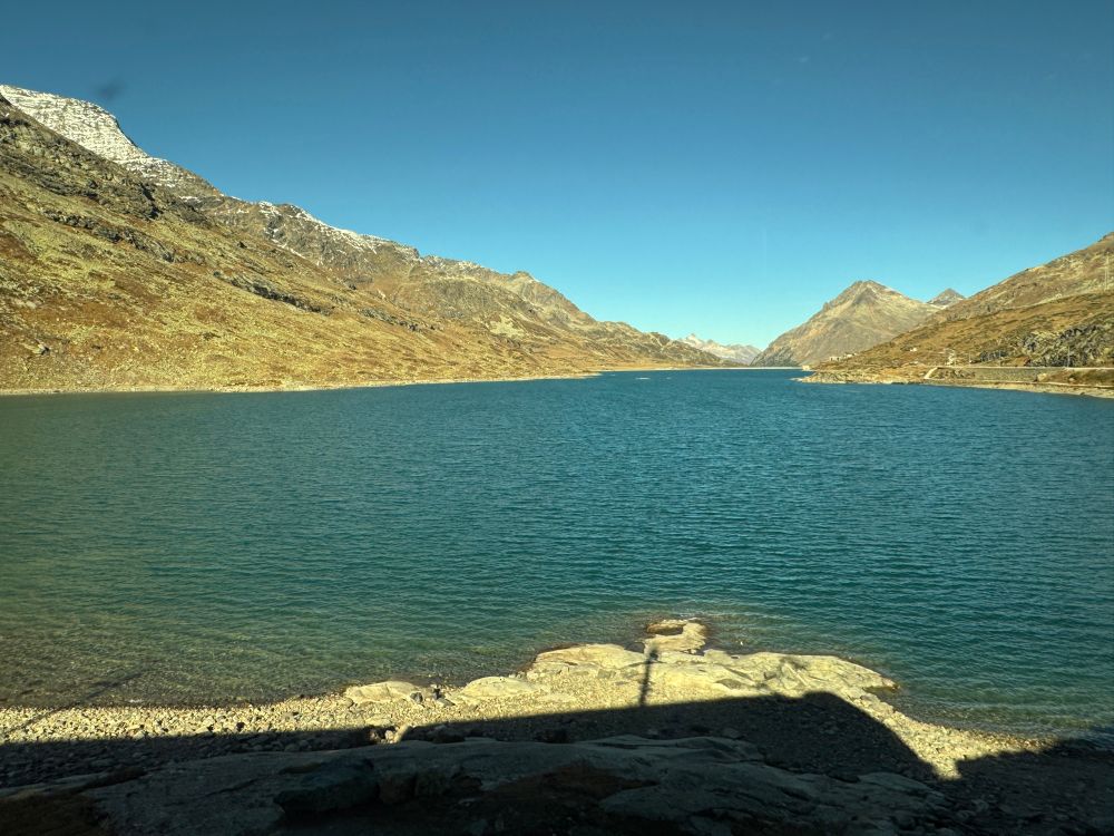 A blue lake with mountains sloping. 