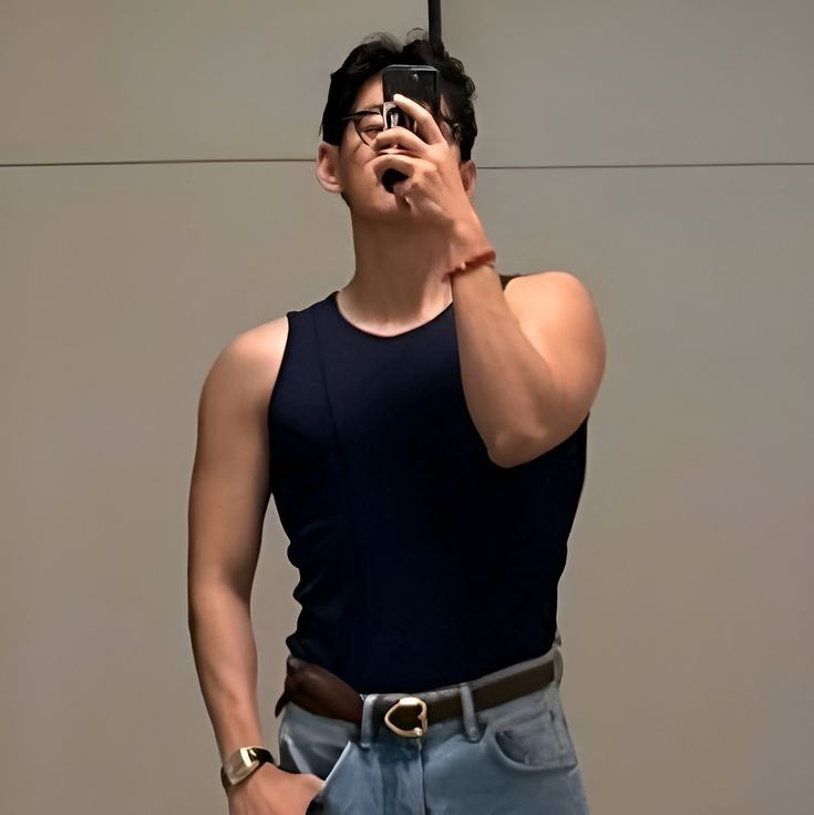 tae mirror selfie with navy tank top and blue jeans. buff arms in 4k