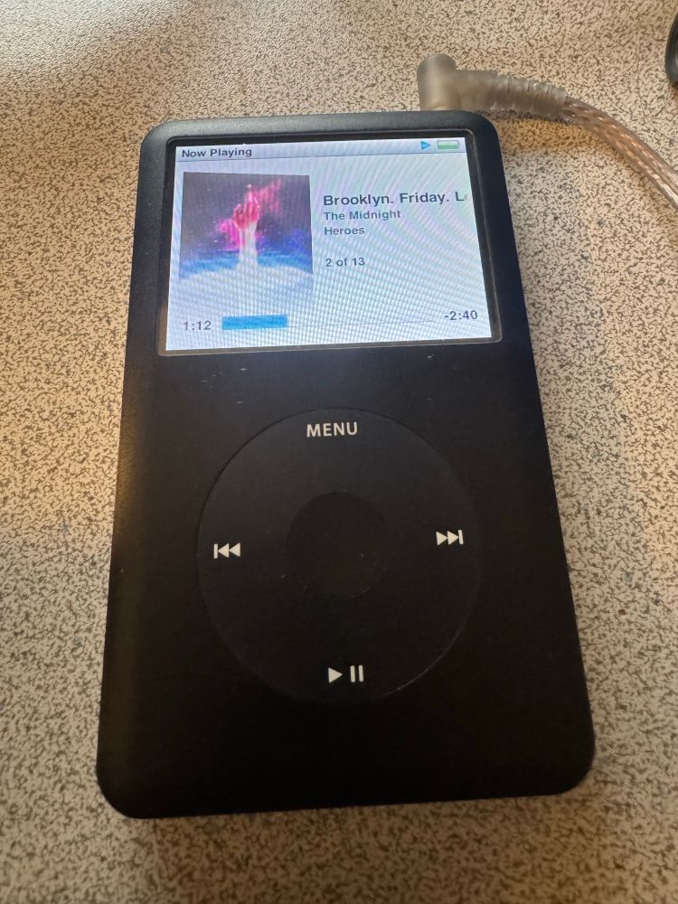 Black 7th gen “Franken” iPod, playing The Midnight.