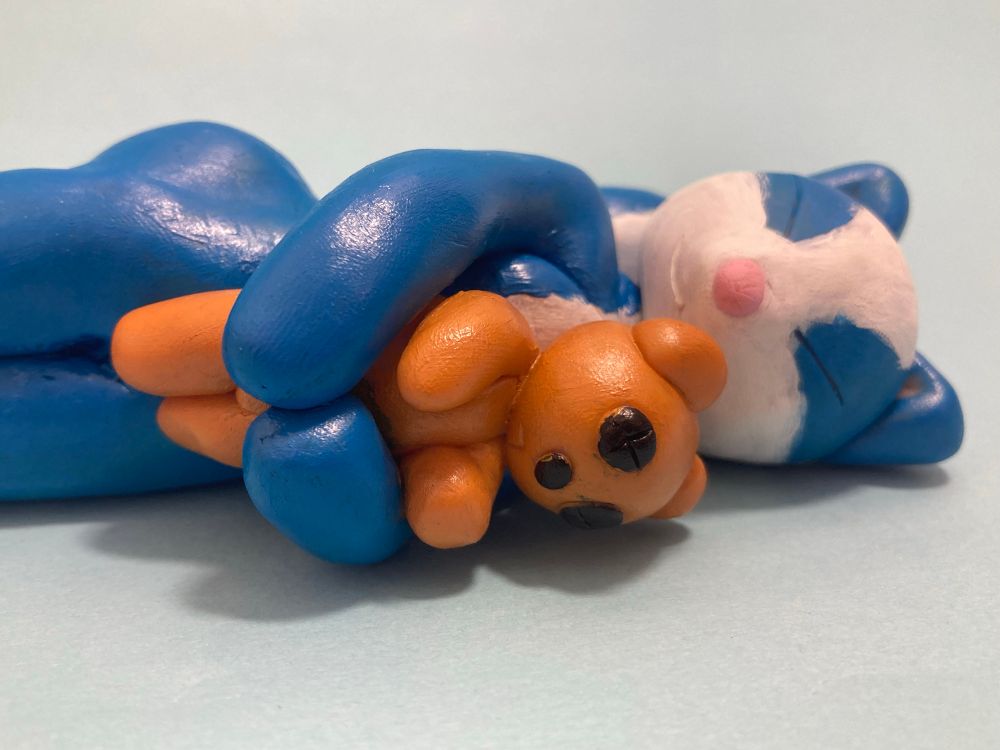 Spike, the skunk cuddling his plushie as he sleeps 🩷