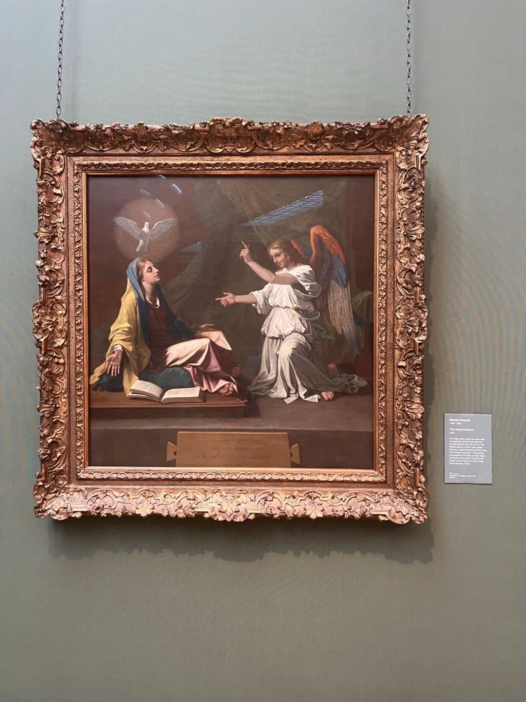 The Annunciation, a painting by Nicolas Poussin. Mary is enraptured, a haloed dove flying over her head. Meanwhile a rainbow-winged Gabriel is doing SICK FINGER GUNS at her
