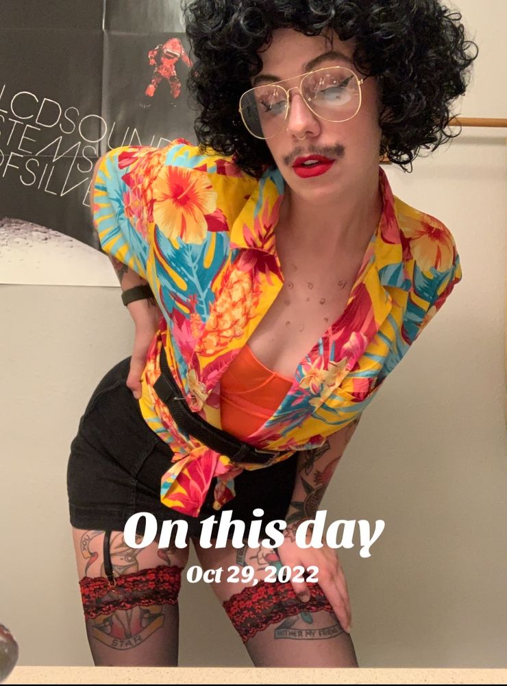 An “on this day 10/29/22” screen shot of me dressed as Sexy weird Al in a Hawaiian shirt, an orange bustier, a short skirt, lace stockings, red lipsticks, big glasses, and a curly black wig 