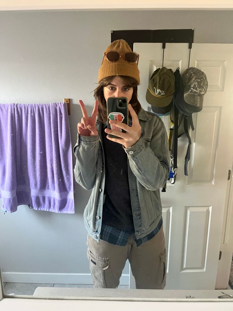 A mirror selfie of me, a brunette white person wearing a Levi jacket and khakis and a brown beanie 